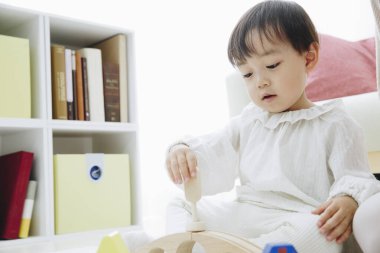 Evde oyuncaklarla oynayan tatlı bir Japon kızı.