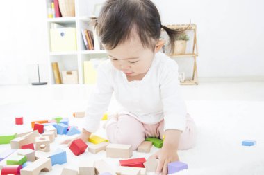 Odasında tahta bloklar olan sevimli küçük çocuk.