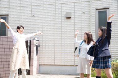 Asyalı bir adam karısına ve kızına veda ediyor.