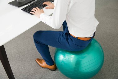 Ofiste bilgisayarla top oynayan genç işadamı