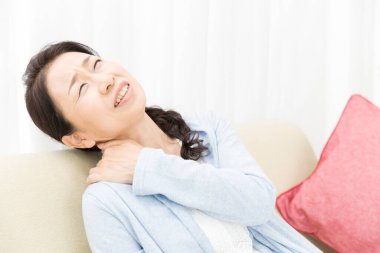 Asyalı kadın boynunda ağrı hissediyor.