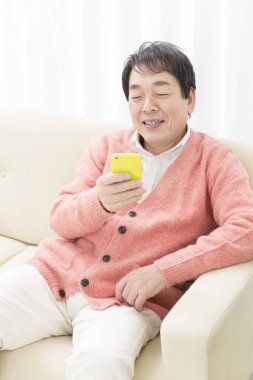 Evde cep telefonu kullanan kıdemli adam. 