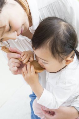 Evdeki oturma odasında genç annesiyle oynayan tatlı bir Japon kızı.