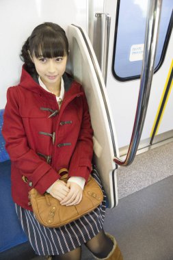 Trende oturan Japon kız.