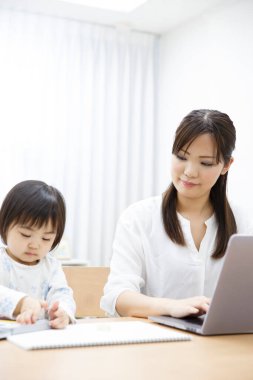 Anne ve kızı dizüstü bilgisayar kullanıyor.