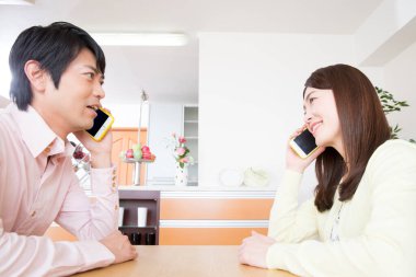 Evde akıllı telefonları olan genç bir çift.