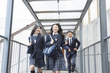 Okulda çantalı genç Japon öğrencilerin portresi.