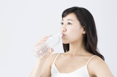 Şişeden su içen Asyalı kız.