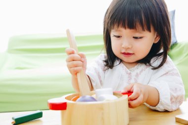 Evdeki oturma odasında oynayan tatlı Asyalı küçük kız.