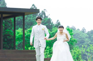 Parkta poz veren Asyalı gelin ve damat 