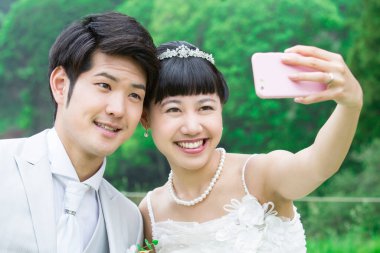 Asyalı gelin ve damat selfie çekiyor. 