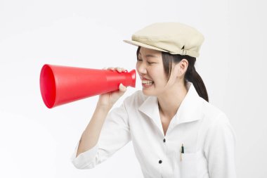 Kırmızı megafonlu güzel Asyalı kadın beyaz arka planda izole edilmiş.