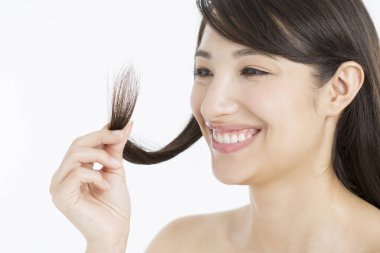 Stüdyoda saçını tutan genç ve güzel bir kadın.