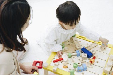 Evde annesiyle oynayan tatlı Asyalı kız.