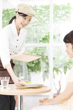 Ziyaretçilere yemek servisi yapan Asyalı garson. 