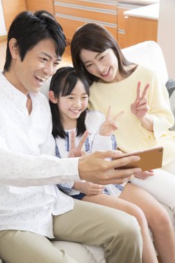 Akıllı telefonlu aile selfie çekiyor.