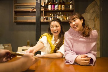 Bardaki genç mutlu Asyalı kadın arkadaşlarının portresi.