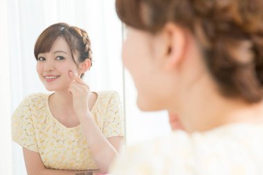 Banyoda aynada kendine bakan bir kadın.