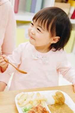 Güzel Asyalı kız evde Japon yemeği yiyor.