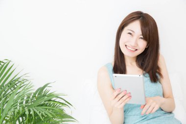 evde tablet bilgisayar kullanan kadın