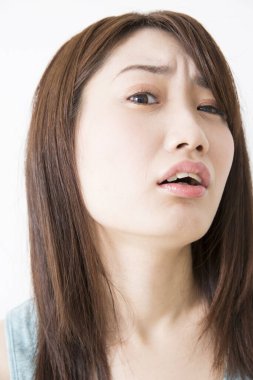 Genç Asyalı kadın şüpheli bir şekilde kameraya bakıyor.