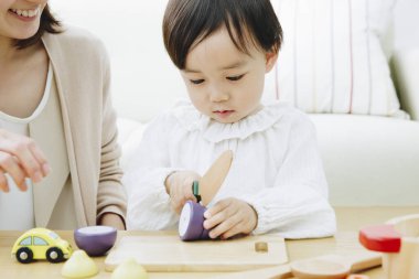 Evde annesiyle oynayan tatlı Asyalı kız.