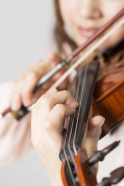 Genç, güzel Asyalı kadın keman çalıyor.