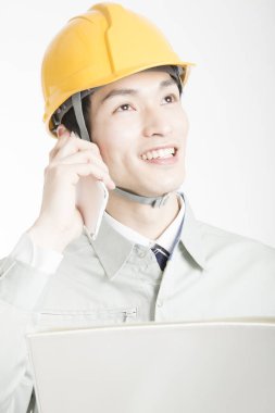 Beyaz stüdyo arka planında poz veren kasklı yakışıklı Japon bir adamın portresi.