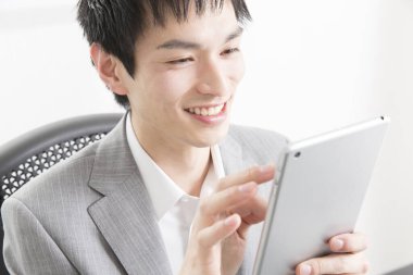 Ofisinde tableti olan genç Asyalı iş adamı.