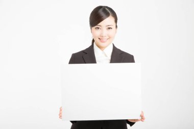 Genç Asyalı kadın beyaz arka planda izole edilmiş boş bir karta uluyor. 