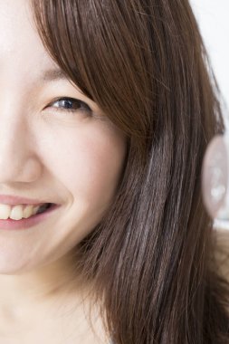 Genç Asyalı kadın yakından gülümsüyor.