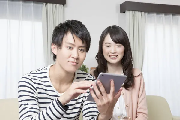 Ευτυχισμένο Ζευγάρι Από Την Ασία Που Χρησιμοποιεί Tablet Στο Σπίτι — Φωτογραφία Αρχείου