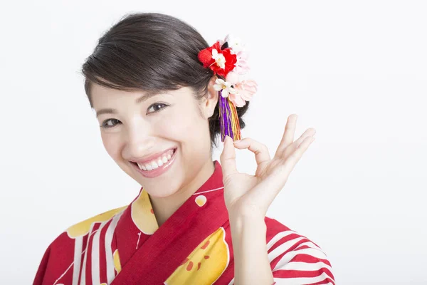 穿着日本传统服装的女人看着相机 展示着好的标志 — 图库照片