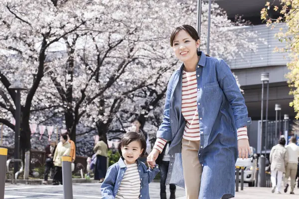 Annesiyle yürüyen sevimli Japon çocuğunun portresi.