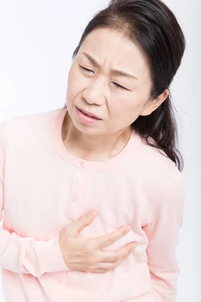 上のアジアの女性は胸に痛みを持っています 心臓発作 白で孤立 — ストック写真