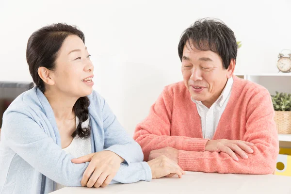 Evde masada oturan yaşlı bir çiftin portresi.