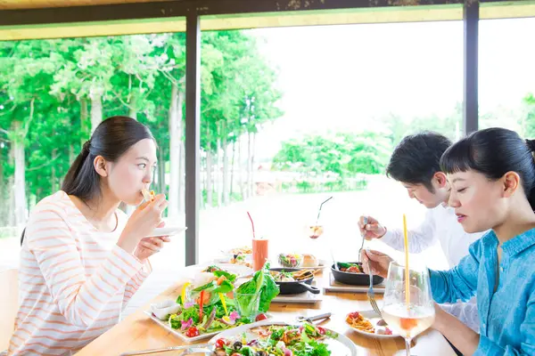 Asyalı arkadaşlar restoranda yemek yiyorlar. 