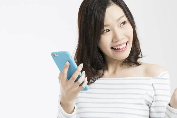 Studio Zdjęcie Pięknej Japońskiej Kobiety Smartfonem Patrząc Białym Tle — Zdjęcie stockowe