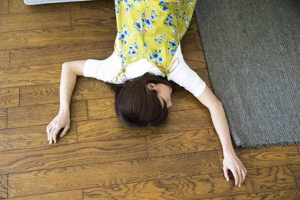 Genç Asyalı kadın evde yerde yatıyor..