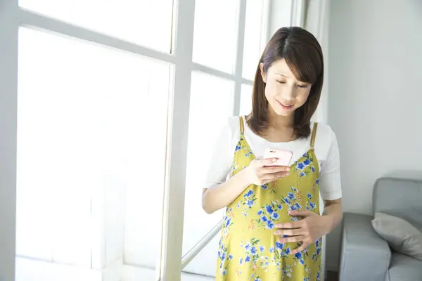 スマートフォンを使用して若いアジアの妊婦の肖像画 — ストック写真