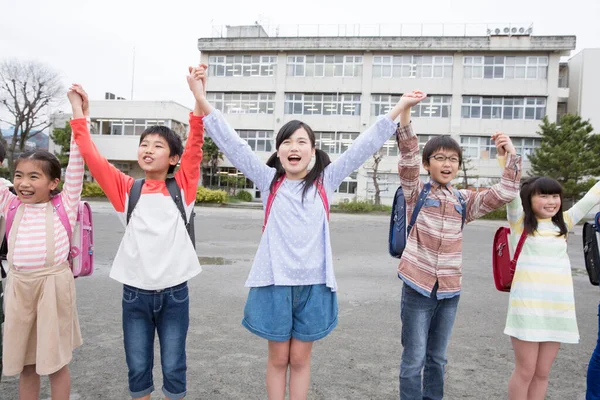 Skupina Japonských Dětí Držících Ruce Nad Hlavou Školním Dvoře — Stock fotografie