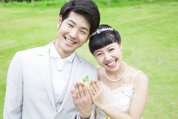 Gelin ve damat parkta yüzükler gösteriyor.