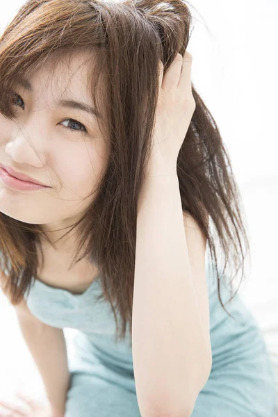 Uzun saçlı Asyalı genç kadının portresi.