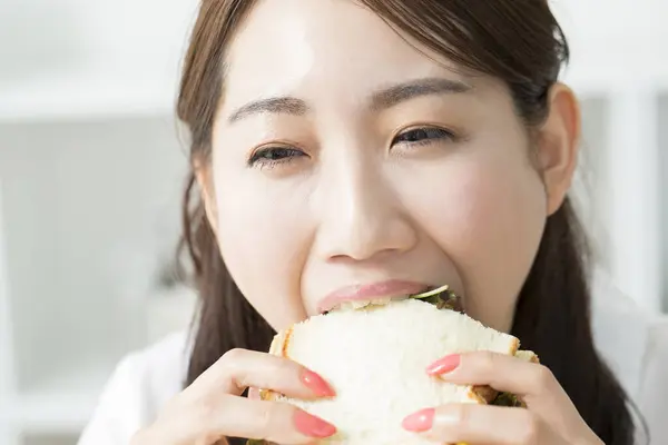 Young Asian Woman Eating Delicious Sandwich — Stock Photo, Image