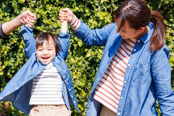 Anne, baba ve küçük kız parkta. 