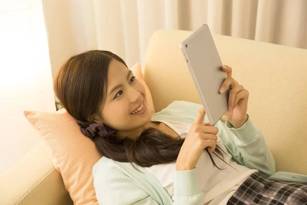 Tablet bilgisayar kullanan Asyalı genç bir kadın..