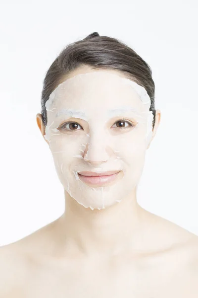 Krásná Asijská Žena Plátěnou Maskou Bílém Pozadí Koncept Péče Pleť — Stock fotografie