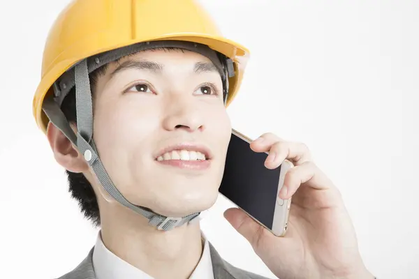 電話で話すハードハットと日本の若いビジネスマンのクローズアップポートレート — ストック写真
