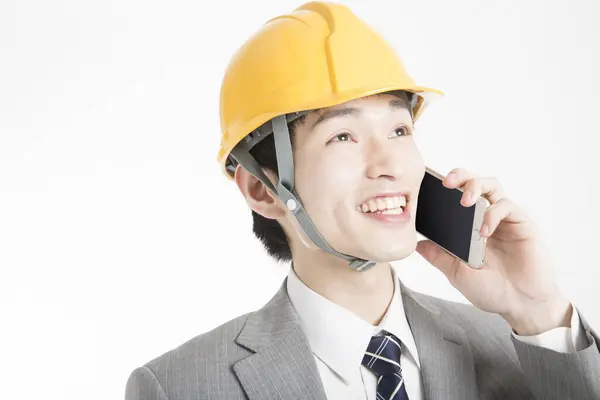 電話で話すハードハットと日本の若いビジネスマンのクローズアップポートレート — ストック写真