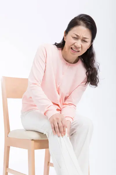 膝の痛みに苦しんでいるシニアアジアの女性 — ストック写真